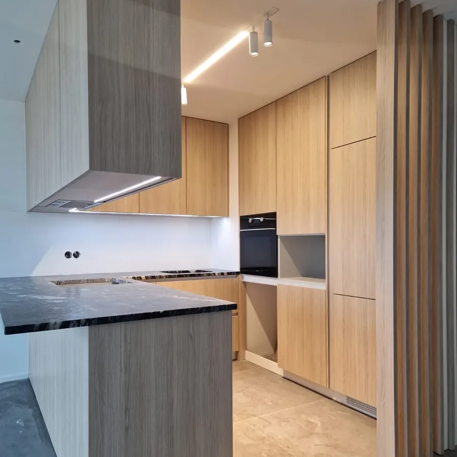 Cozinha com revestimento em madeira e eletrodomésticos encastrados